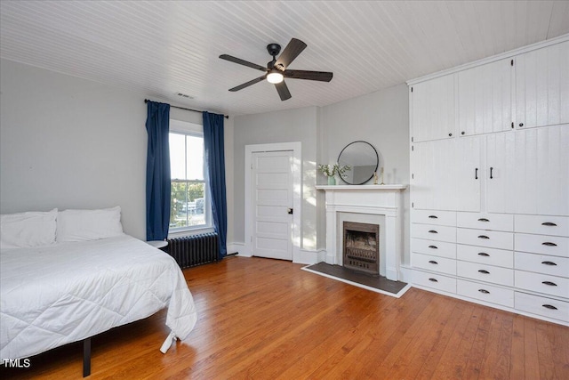 bedroom featuring ceiling fan, radiator, and wood-type flooring