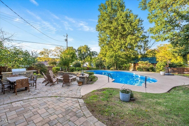 view of swimming pool with grilling area, a lawn, a fire pit, and a patio area