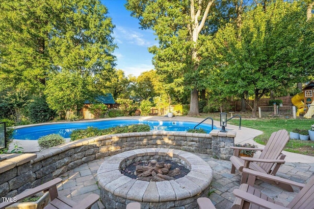 view of swimming pool with a fire pit and a patio