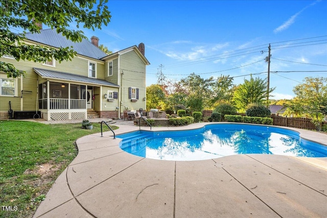 view of swimming pool with a sunroom, a lawn, and a patio