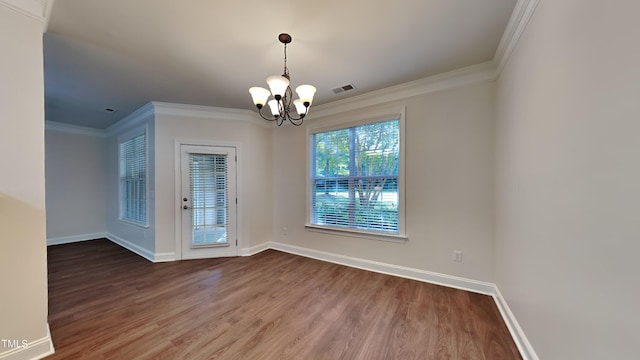 unfurnished dining area featuring ornamental molding, an inviting chandelier, and hardwood / wood-style floors