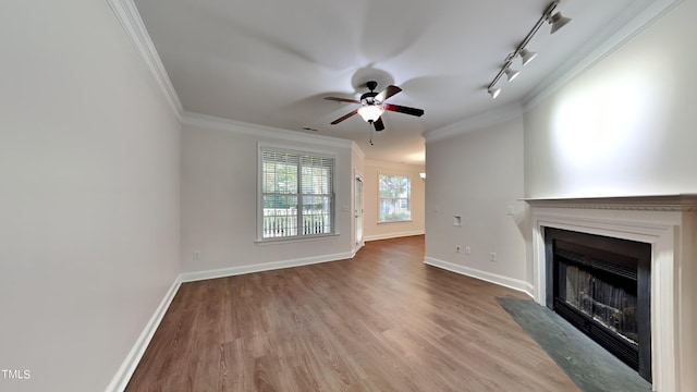 unfurnished living room with ceiling fan, hardwood / wood-style flooring, crown molding, and rail lighting