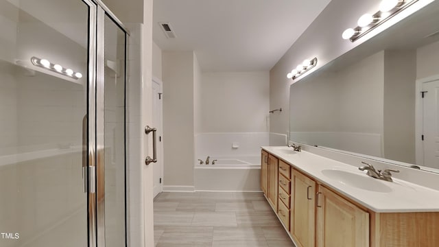 bathroom featuring shower with separate bathtub and vanity