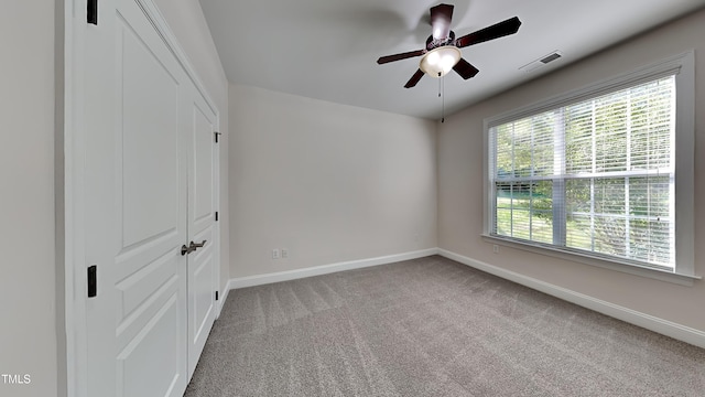 unfurnished bedroom with ceiling fan, a closet, and light colored carpet