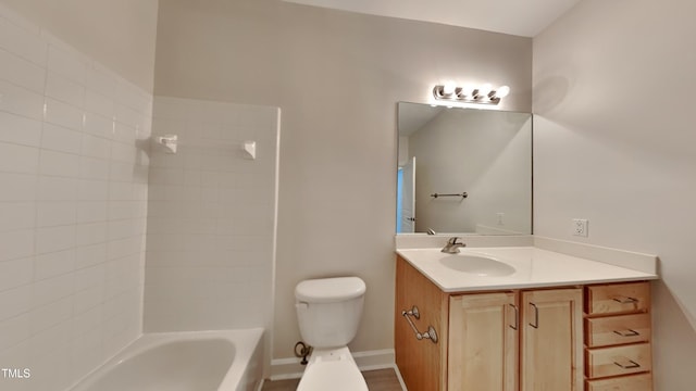 full bathroom with tiled shower / bath, vanity, and toilet