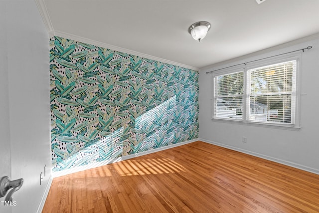 empty room with crown molding and wood-type flooring