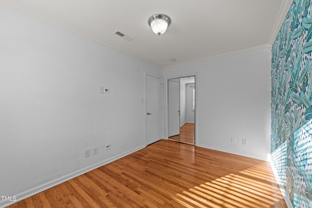 spare room with crown molding and light hardwood / wood-style flooring