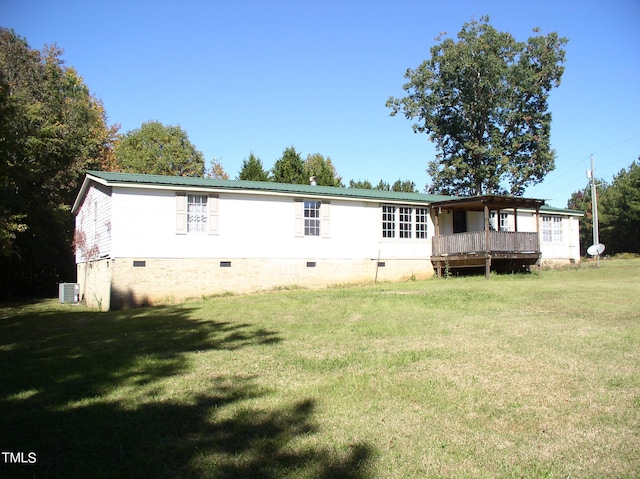 rear view of house featuring central AC, a wooden deck, and a lawn