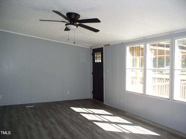 spare room featuring crown molding, a textured ceiling, ceiling fan, and dark hardwood / wood-style flooring