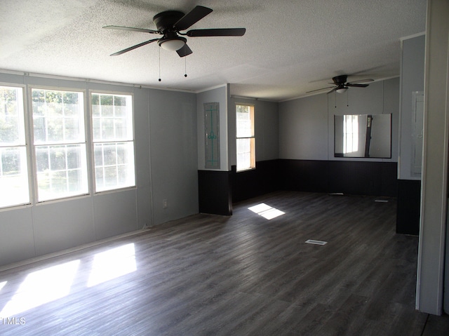 spare room with ornamental molding, dark wood-type flooring, a textured ceiling, and ceiling fan