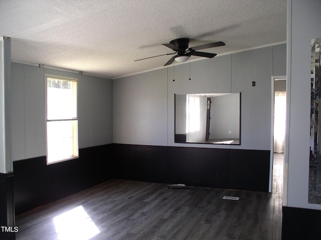 empty room with a textured ceiling, dark hardwood / wood-style floors, and ceiling fan