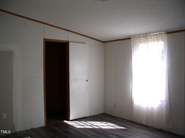 unfurnished room featuring crown molding, hardwood / wood-style floors, a textured ceiling, and lofted ceiling