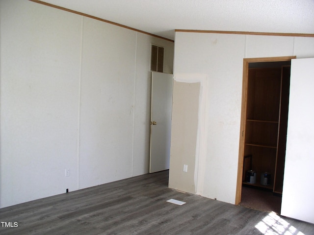 spare room with ornamental molding, lofted ceiling, dark hardwood / wood-style floors, and a textured ceiling