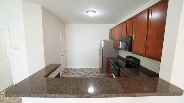 kitchen with brown cabinets, dark stone countertops, visible vents, black appliances, and a peninsula