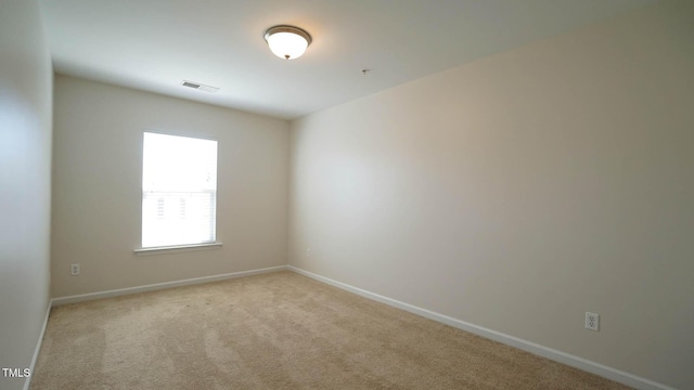 carpeted spare room with baseboards and visible vents
