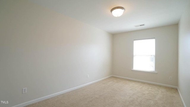 unfurnished room with visible vents, baseboards, and light carpet