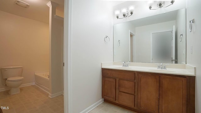 bathroom with baseboards, a sink, double vanity, and toilet