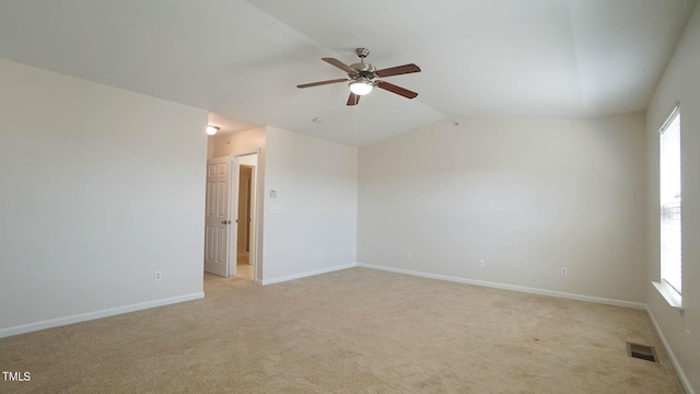 unfurnished room with lofted ceiling, visible vents, light carpet, baseboards, and ceiling fan