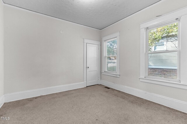 810 E Edenton St, Raleigh, NC 27601 - empty room with light colored carpet, a textured ceiling, healthy amount of natural light, and crown molding