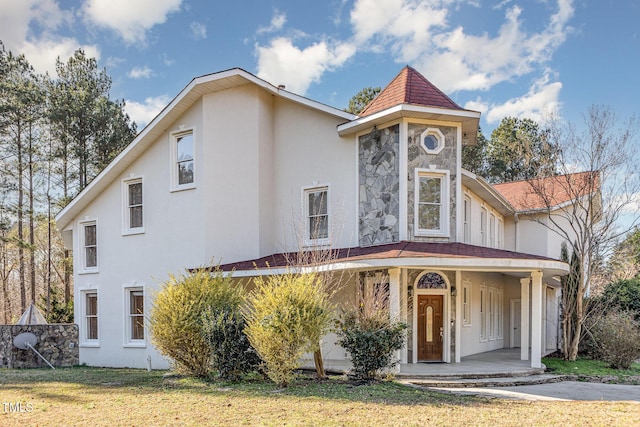 view of front of house featuring covered porch and a front yard