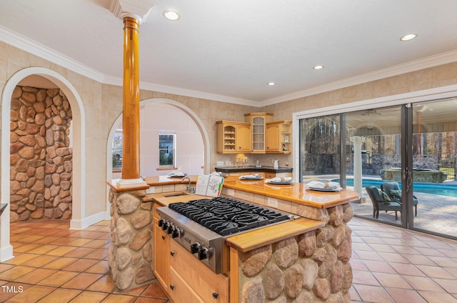 kitchen with light brown cabinets, light tile patterned floors, stainless steel gas cooktop, and crown molding