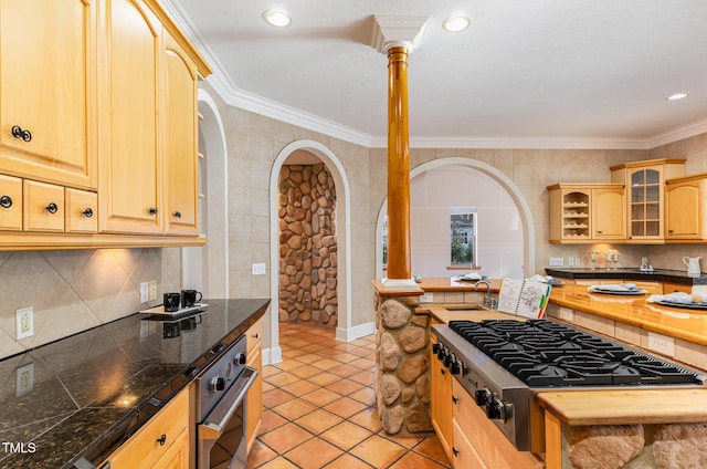 kitchen with light brown cabinets, stainless steel appliances, and ornamental molding