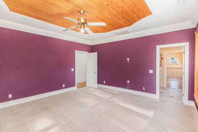 unfurnished bedroom with carpet, wood ceiling, a raised ceiling, ceiling fan, and crown molding