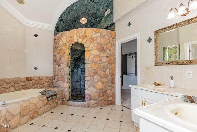 bathroom with a bathing tub, vanity, crown molding, and tile walls