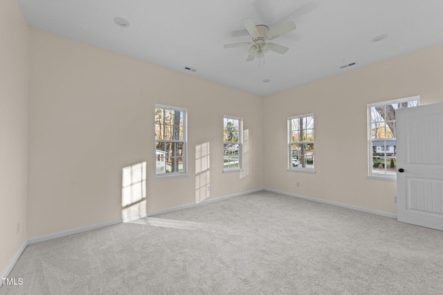 spare room with ceiling fan and light carpet