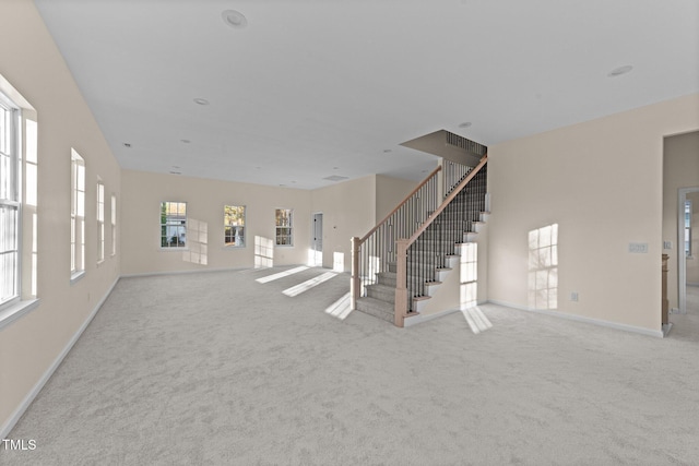 unfurnished living room featuring light colored carpet