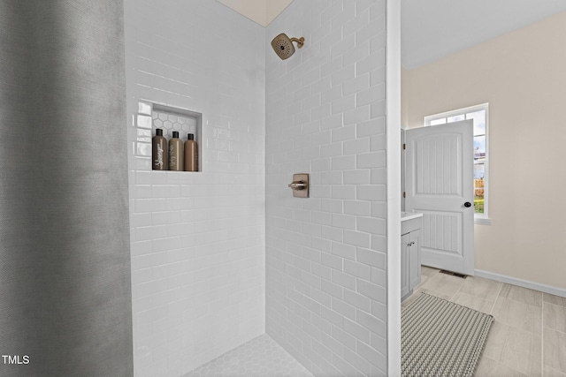 bathroom with vanity and a tile shower