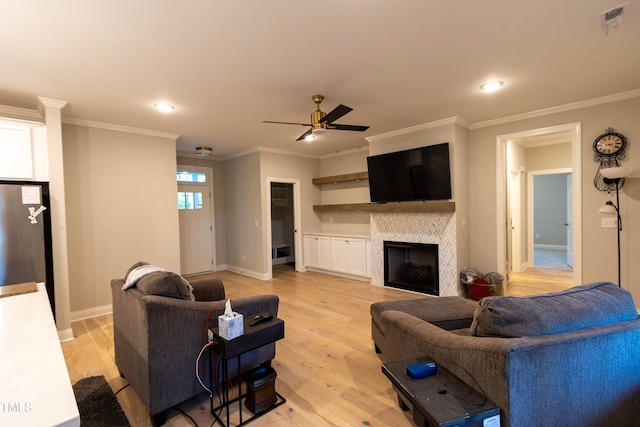 living room featuring crown molding, light wood-type flooring, and ceiling fan