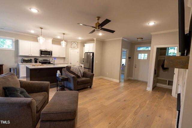 living room featuring light hardwood / wood-style flooring, ornamental molding, sink, and ceiling fan