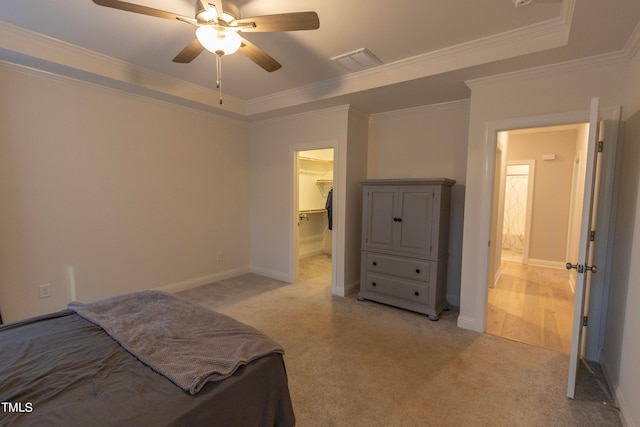 carpeted bedroom with a spacious closet, ceiling fan, a closet, and ornamental molding