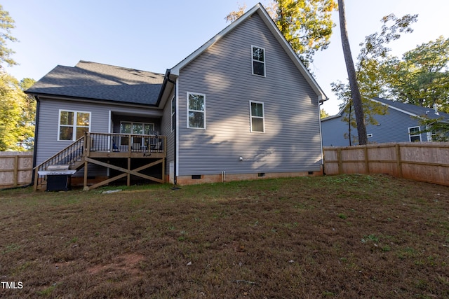 rear view of property with a deck and a lawn