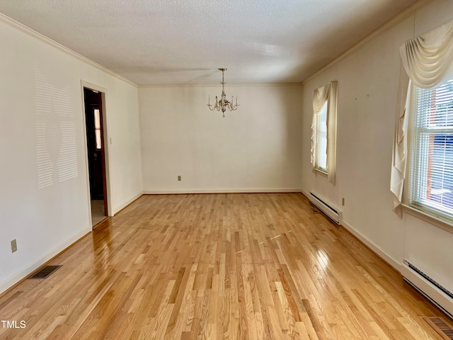 empty room with baseboard heating, a chandelier, a textured ceiling, and light hardwood / wood-style floors