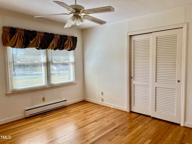 unfurnished bedroom with a textured ceiling, a closet, ceiling fan, light hardwood / wood-style floors, and baseboard heating