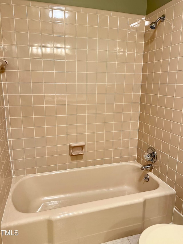 bathroom featuring tiled shower / bath and toilet