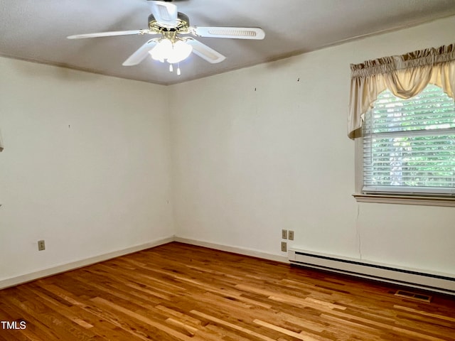 empty room featuring ceiling fan, hardwood / wood-style flooring, and a baseboard radiator