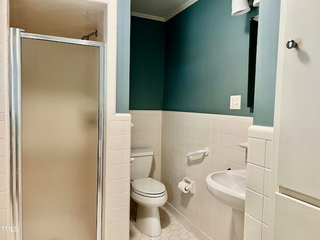 bathroom with a shower with door, toilet, tile patterned floors, tile walls, and ornamental molding