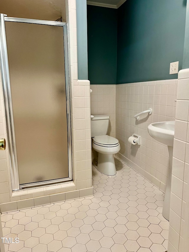 bathroom with tile walls, toilet, and an enclosed shower