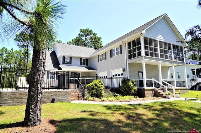 view of front of home featuring a sunroom and a front yard