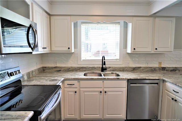 kitchen featuring decorative backsplash, white cabinets, appliances with stainless steel finishes, and sink