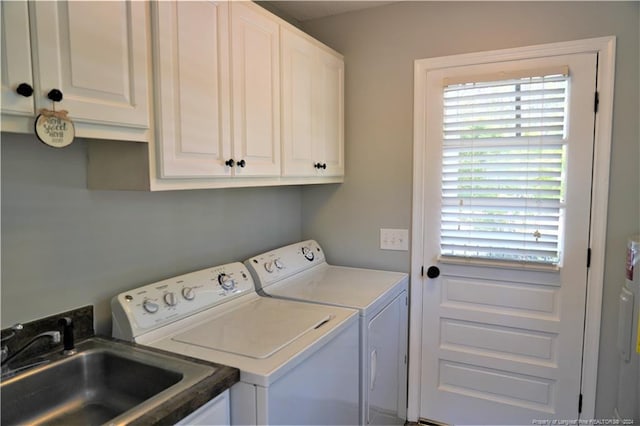 washroom with washer and dryer, sink, and cabinets