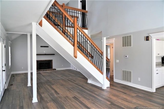 stairway featuring hardwood / wood-style flooring and high vaulted ceiling