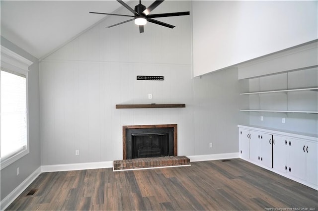 unfurnished living room featuring a fireplace, plenty of natural light, dark hardwood / wood-style flooring, and high vaulted ceiling