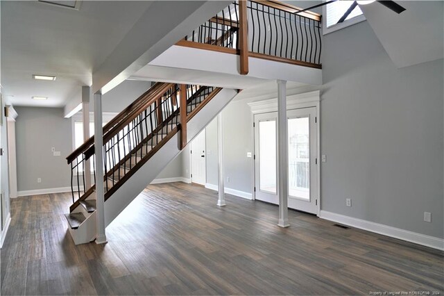 foyer entrance featuring ornate columns and dark hardwood / wood-style flooring