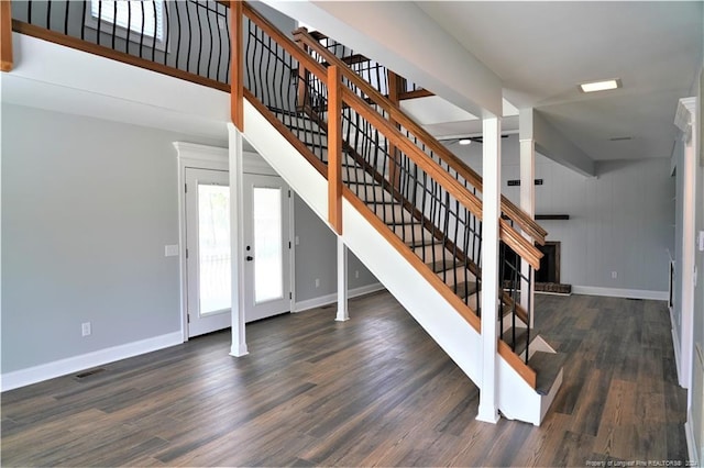 stairs with french doors, hardwood / wood-style flooring, and wood walls