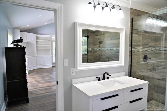 bathroom with hardwood / wood-style floors, lofted ceiling, tiled shower, and vanity