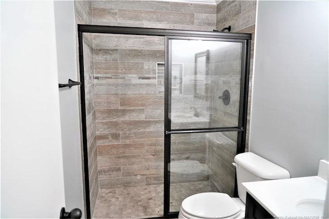 bathroom featuring an enclosed shower, vanity, and toilet